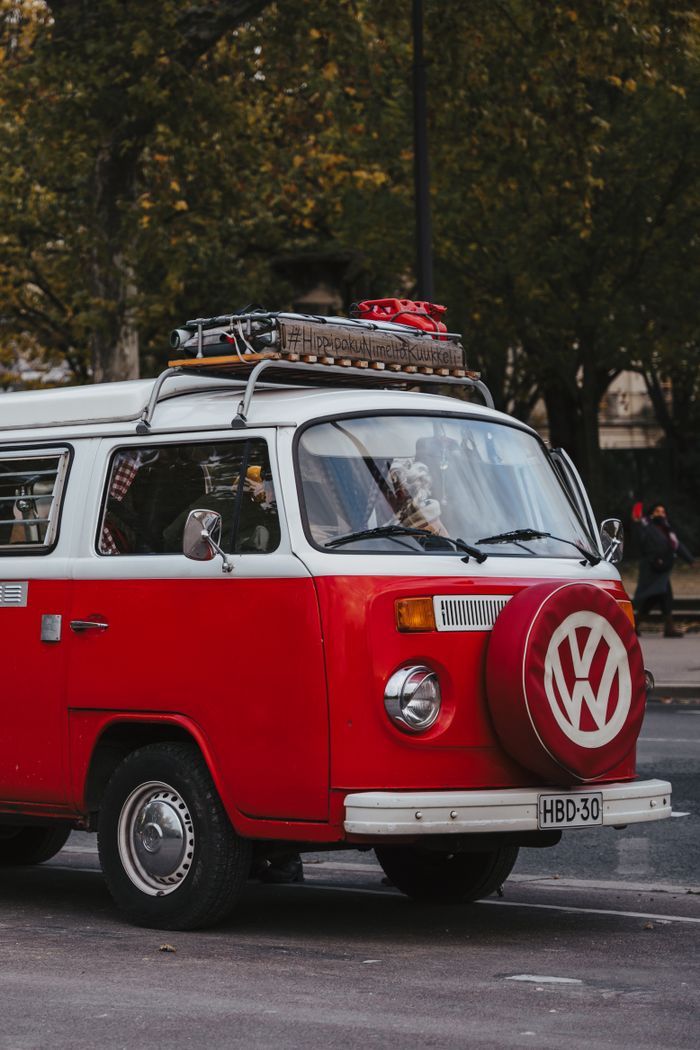 product-04 Red vintage Volkswagen bus parked on a city street, showcasing nostalgia and retro style.